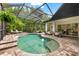 Beautiful screened pool with a waterfall feature surrounded by lush landscaping at 15045 Wind Whisper Dr, Odessa, FL 33556