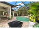 Relax in this screened-in pool area with a firepit and outdoor seating, perfect for enjoying the outdoors at 15045 Wind Whisper Dr, Odessa, FL 33556