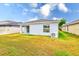 Wide backyard with a white house, green grass, and a white fence at 15410 Quail Woods Pl, Ruskin, FL 33573