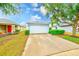 Home exterior with a two-car garage, well-maintained landscaping, and a driveway at 15410 Quail Woods Pl, Ruskin, FL 33573