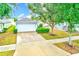 Charming single-Gathering home featuring a well-manicured lawn, mature trees, and a two-car garage at 15410 Quail Woods Pl, Ruskin, FL 33573