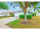 Beautiful single-story home with a well-manicured lawn, lush landscaping, and attached garage at 15410 Quail Woods Pl, Ruskin, FL 33573