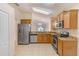 Well-lit kitchen features stainless steel appliances, ample cabinet space, and granite countertops at 15410 Quail Woods Pl, Ruskin, FL 33573