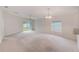 Spacious living room featuring neutral carpet, ceiling fan, and sliding glass doors to the backyard at 15410 Quail Woods Pl, Ruskin, FL 33573