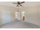 Main bedroom with ceiling fan, carpet, and ensuite bathroom and walk-in closet access at 15410 Quail Woods Pl, Ruskin, FL 33573