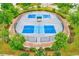 Overhead view of a community pickleball court surrounded by lush landscaping and trees at 15410 Quail Woods Pl, Ruskin, FL 33573