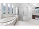 Elegant bathroom showcasing a corner tub, glass shower, and plenty of natural light at 16522 Ivy Lake Dr, Odessa, FL 33556