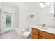 Bright bathroom featuring a tub/shower combo, wood vanity, and a door leading to the outdoors at 16522 Ivy Lake Dr, Odessa, FL 33556