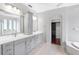 A luxurious bathroom with double vanity, modern gray cabinets, and access to a walk-in closet at 16522 Ivy Lake Dr, Odessa, FL 33556