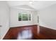 Bedroom with hardwood floors, a ceiling fan, and a large window providing natural light at 16522 Ivy Lake Dr, Odessa, FL 33556