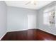 Cozy bedroom featuring a ceiling fan, hardwood floors, and a bright window at 16522 Ivy Lake Dr, Odessa, FL 33556