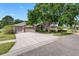 Exterior shot features a wide driveway, lush lawn, mature trees, and a neutral-toned house at 16522 Ivy Lake Dr, Odessa, FL 33556