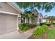 Charming home exterior with well-manicured landscaping, a brick walkway, and an attached garage at 16522 Ivy Lake Dr, Odessa, FL 33556