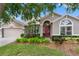Charming single-story home with well-maintained landscaping, a red front door and neutral color palette at 16522 Ivy Lake Dr, Odessa, FL 33556
