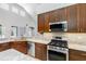 Well-equipped kitchen features stainless steel appliances, granite countertops, and wooden cabinetry at 16522 Ivy Lake Dr, Odessa, FL 33556