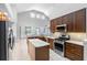 Spacious kitchen with stainless steel appliances, island, dark wood cabinets, and modern finishes at 16522 Ivy Lake Dr, Odessa, FL 33556