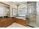 Well-lit bathroom featuring a glass shower, a tub with dark countertops and earth-toned tiles at 1737 Brightwaters Ne Blvd, St Petersburg, FL 33704