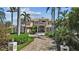 Stately two-story home featuring a brick driveway, grand entrance, lush landscaping, and mature palm trees at 1737 Brightwaters Ne Blvd, St Petersburg, FL 33704