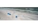 Beautiful aerial shot of the beach shows the sand, ocean and the blue beach umbrellas at 18650 Gulf Blvd # 601, Indian Shores, FL 33785