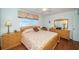 Comfortable bedroom with wood flooring, ceiling fan and beautiful floral patterned comforter at 18650 Gulf Blvd # 601, Indian Shores, FL 33785