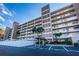 Condominium building featuring multiple balconies, covered entrance, and well-maintained landscaping at 18650 Gulf Blvd # 601, Indian Shores, FL 33785