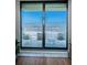 View through the glass doors to a balcony with patio furniture and a view of the beach and ocean at 18650 Gulf Blvd # 601, Indian Shores, FL 33785