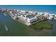 Scenic aerial shot showing waterfront condos with a community pool, boat slips, and tennis court at 19451 Gulf Blvd # 211, Indian Shores, FL 33785