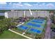 Aerial view of condos with a tennis court, and well-maintained landscaping at 19451 Gulf Blvd # 211, Indian Shores, FL 33785