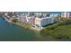 Aerial image showcasing condo with waterfront access, a pool, and lush landscaping at 19451 Gulf Blvd # 211, Indian Shores, FL 33785