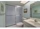 Bathroom with sliding glass shower doors, vanity, and beach-themed decor at 19451 Gulf Blvd # 211, Indian Shores, FL 33785