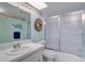 Bathroom featuring a shower with sliding glass doors, vanity, and decorative accents at 19451 Gulf Blvd # 211, Indian Shores, FL 33785