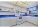 This kitchen has white cabinets, blue countertops, and modern appliances at 19451 Gulf Blvd # 211, Indian Shores, FL 33785