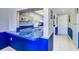 View of kitchen pass-through with blue countertops and white cabinetry at 19451 Gulf Blvd # 211, Indian Shores, FL 33785
