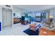 Bright living room features plush seating, mirrored wall, and sliding glass doors to outdoor balcony at 19451 Gulf Blvd # 211, Indian Shores, FL 33785