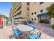 Community patio area featuring barbecue grills, outdoor seating, and building facade at 19451 Gulf Blvd # 211, Indian Shores, FL 33785