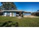 Expansive backyard featuring a covered patio, blue shed, and ample space for recreation and gardening at 1965 Allard Dr, Clearwater, FL 33763