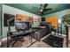 Cozy bedroom featuring dark green walls and ceiling, a ceiling fan, and an organized workspace at 1965 Allard Dr, Clearwater, FL 33763