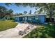 Blue home with a well-maintained lawn, a long driveway and mature trees at 1965 Allard Dr, Clearwater, FL 33763