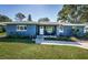 Charming one story home with a lush lawn, classic curb appeal and rocking chairs at 1965 Allard Dr, Clearwater, FL 33763