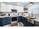 Well-lit kitchen with stainless steel appliances, white subway tile, and two-tone navy and white cabinets at 1965 Allard Dr, Clearwater, FL 33763