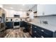 Well-lit kitchen with stainless steel appliances, white subway tile, and two-tone navy and white cabinets at 1965 Allard Dr, Clearwater, FL 33763