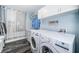 Bright laundry room with modern washer and dryer, ample cabinet storage, and hanging rack at 1965 Allard Dr, Clearwater, FL 33763