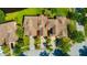 Aerial view of a 3-unit townhouse complex with well-maintained lawns and mature trees at 20305 Oak Key Ct, Tampa, FL 33647