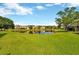 A beautiful view of the community pond with lush lawn, landscaping, and nearby buildings at 20305 Oak Key Ct, Tampa, FL 33647