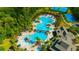 Aerial view of a large community pool with ample seating, a splashpad, and mature landscaping at 20305 Oak Key Ct, Tampa, FL 33647