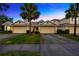 Townhouse exterior features a large driveway, well-maintained landscaping, and a welcoming facade at 20305 Oak Key Ct, Tampa, FL 33647