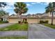 Townhouse exterior features a large driveway, well-maintained landscaping, and a welcoming facade at 20305 Oak Key Ct, Tampa, FL 33647