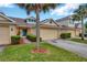 Well-kept townhome with an attached garage, green lawn, and complemented by a tree at 20305 Oak Key Ct, Tampa, FL 33647