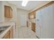 Kitchen featuring tile floors, white appliances and wood cabinets with white countertops at 20305 Oak Key Ct, Tampa, FL 33647
