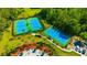 Aerial view of three community tennis courts with lush green surroundings and pool at 20305 Oak Key Ct, Tampa, FL 33647